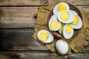 Boiled eggs in bowl. On a wooden background.