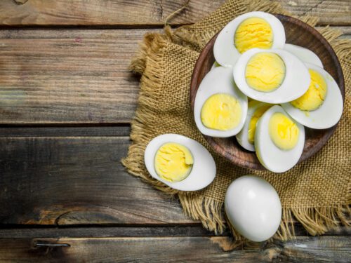 Boiled eggs in bowl. On a wooden background.