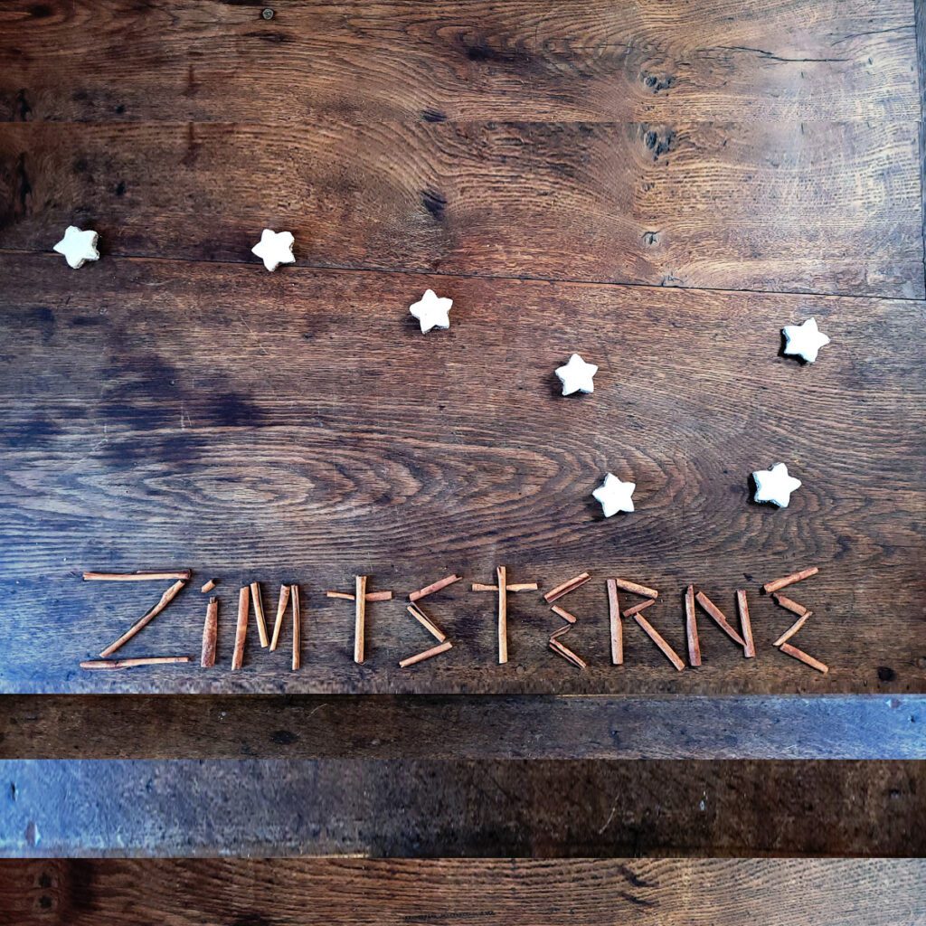 Zimtsterne (cinnamon stars) laid out as the Big Dipper, with the word Zimtsterne spelled out in cinnamon (zimpt) sticks.