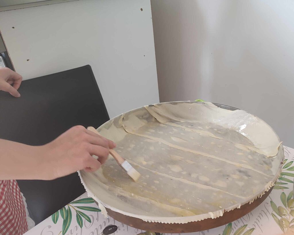 Painting the baklawa dough with butter